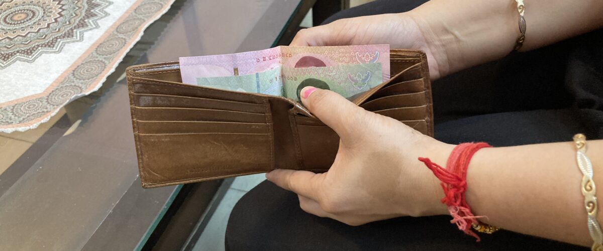 A woman holding a purse with money, representing how to save money on clothes and manage a minimal wardrobe