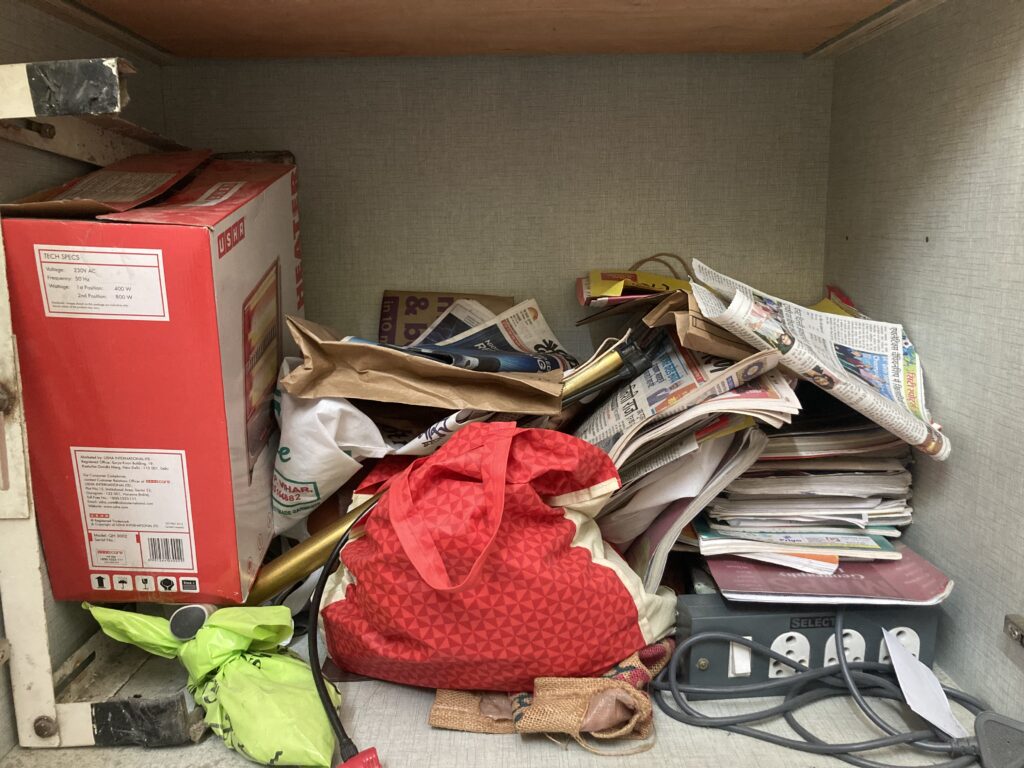 An overcrowded wardrobe filled with cluttered items, showing the need to clear unused and unnecessary belongings.