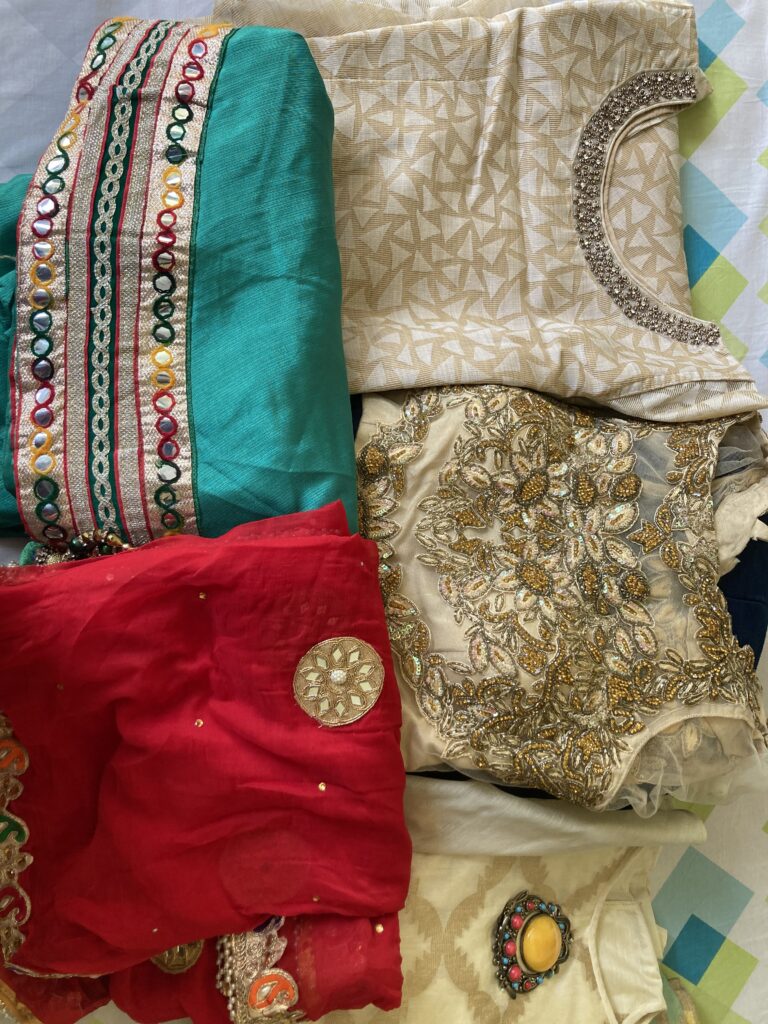 A stack of heavy, full-embroidered clothes carefully stored with the intention of wearing them after marriage.