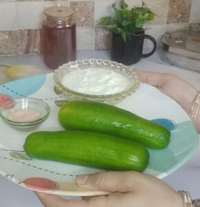 Ingredients for Cooling Cucumber Yogurt recipe including fresh cucumber, creamy yogurt, herbs, and spices arranged on a table for a no cook recipe.