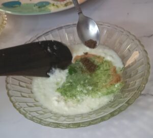 Grated cucumber added to a bowl of fresh curd and gently stirred to make Cooling Cucumber Yogurt.