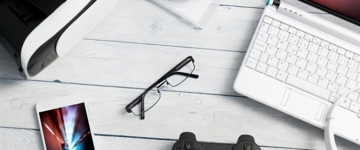 Different electronic essentials organized on a white wooden table, including useful budget-friendly gadgets for daily home use.