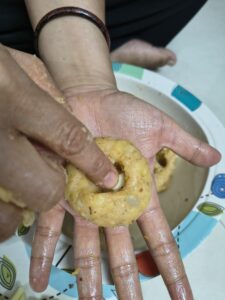 Hands shaping a seasoned potato mixture and stuffing cheese into the center while preparing homemade potato cheese balls.